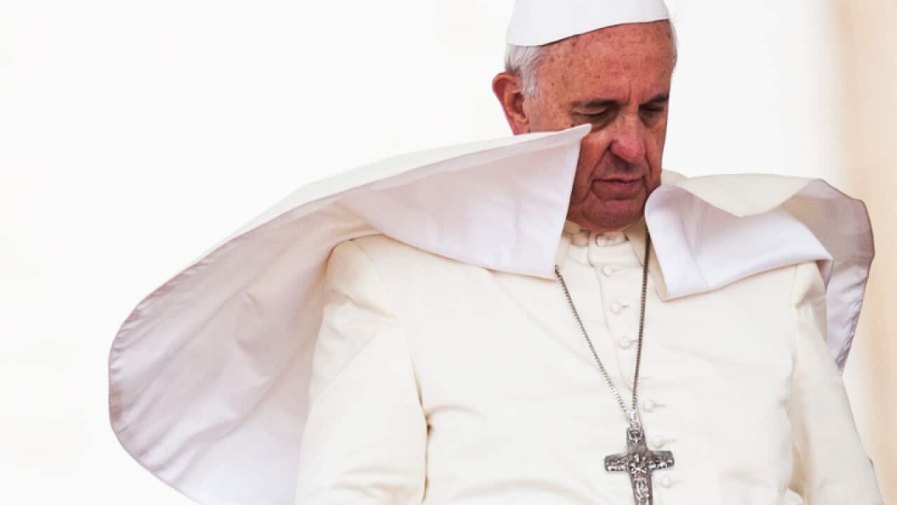 A gust of wind lifts Pope Francis' mantle