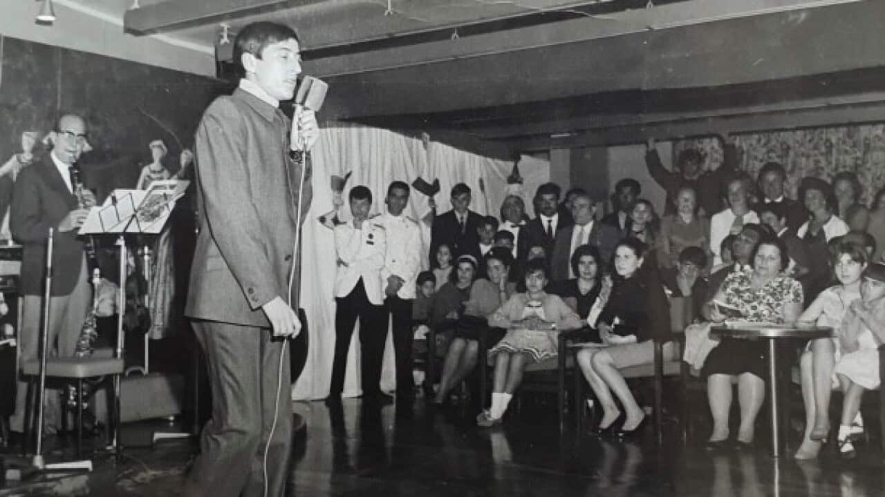 Paolo Buhne singing in front of an audience on the ship taking him to Australia
