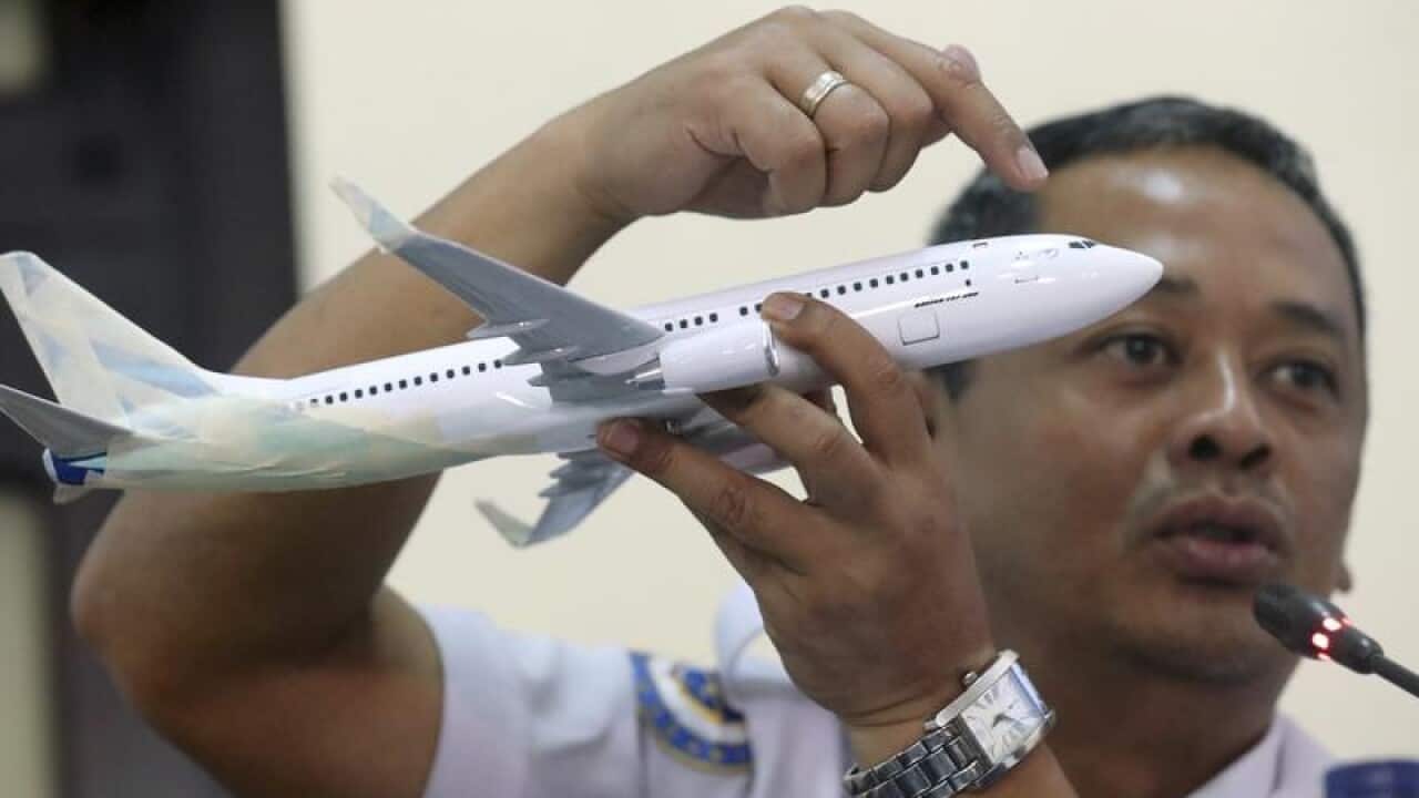 Indonesian air safety investigator with a model plane