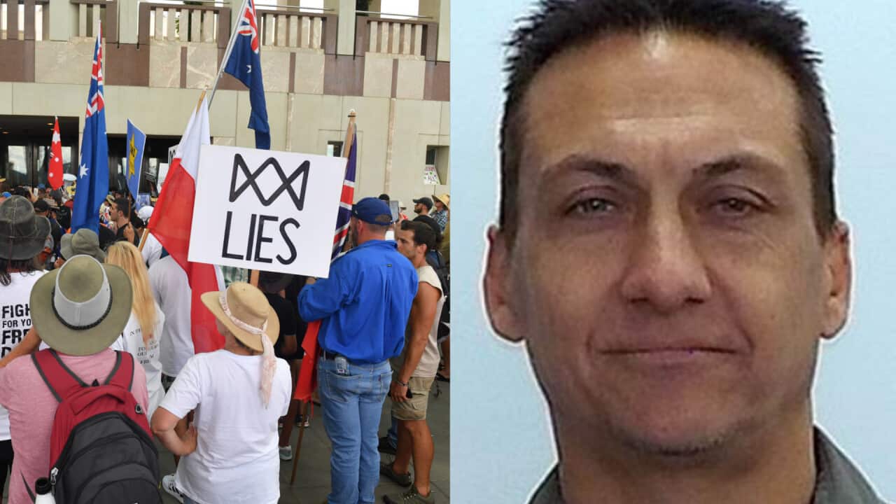 A group of people protesting next to an image of the suspect.