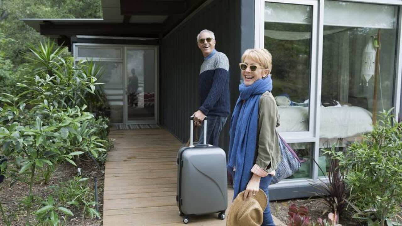 a couple with suitcases arriving at vacation rental