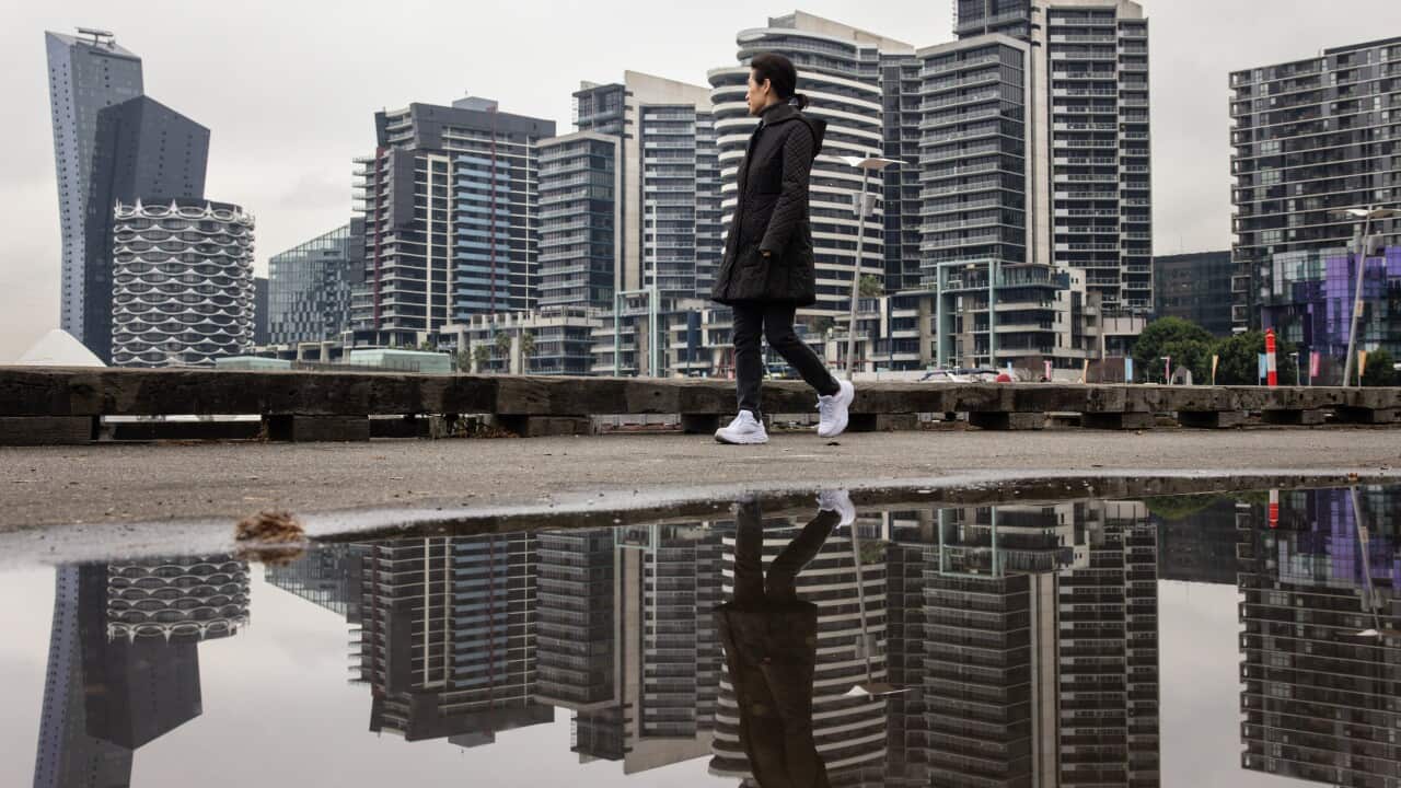 A woman walks along Dockland Harbour during a cold morning in Melbourne.