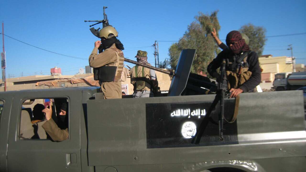 Islamic State group militants patrol in a commandeered Iraqi security forces trucks. (AP Photo, File)