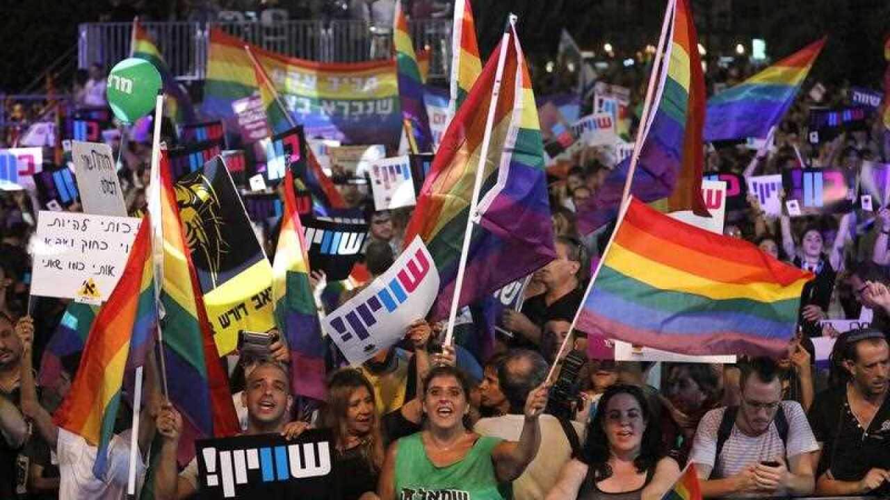 People rally during a demonstration for gay rights in front of the Rabin square in Tel Aviv, Israel. New laws have banned gay men from surrogacy. 