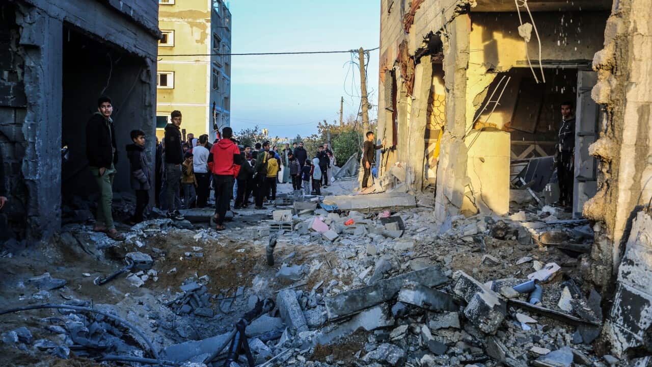 Palestinians inspect damaged apartment buildings in Rafah, Gaza (Getty)
