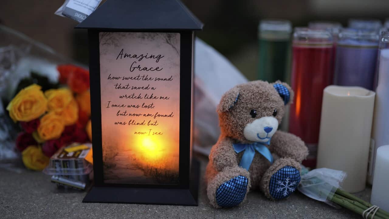 Flowers and candles are placed outside the Abundant Life Christian School Tuesday, Dec. 17, 2024 in Madison, Wis., following a shooting on Monday.