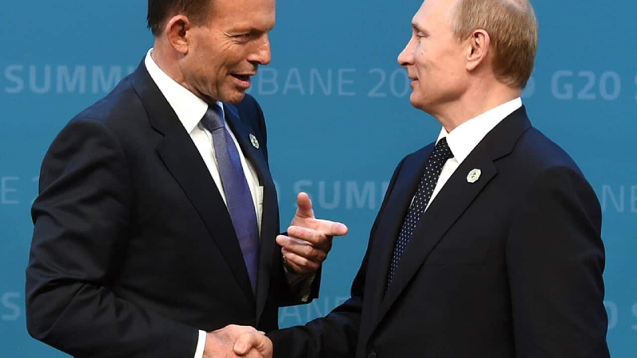 Prime minister Tony Abbott (L) greets Russian President Vladimir Putin
