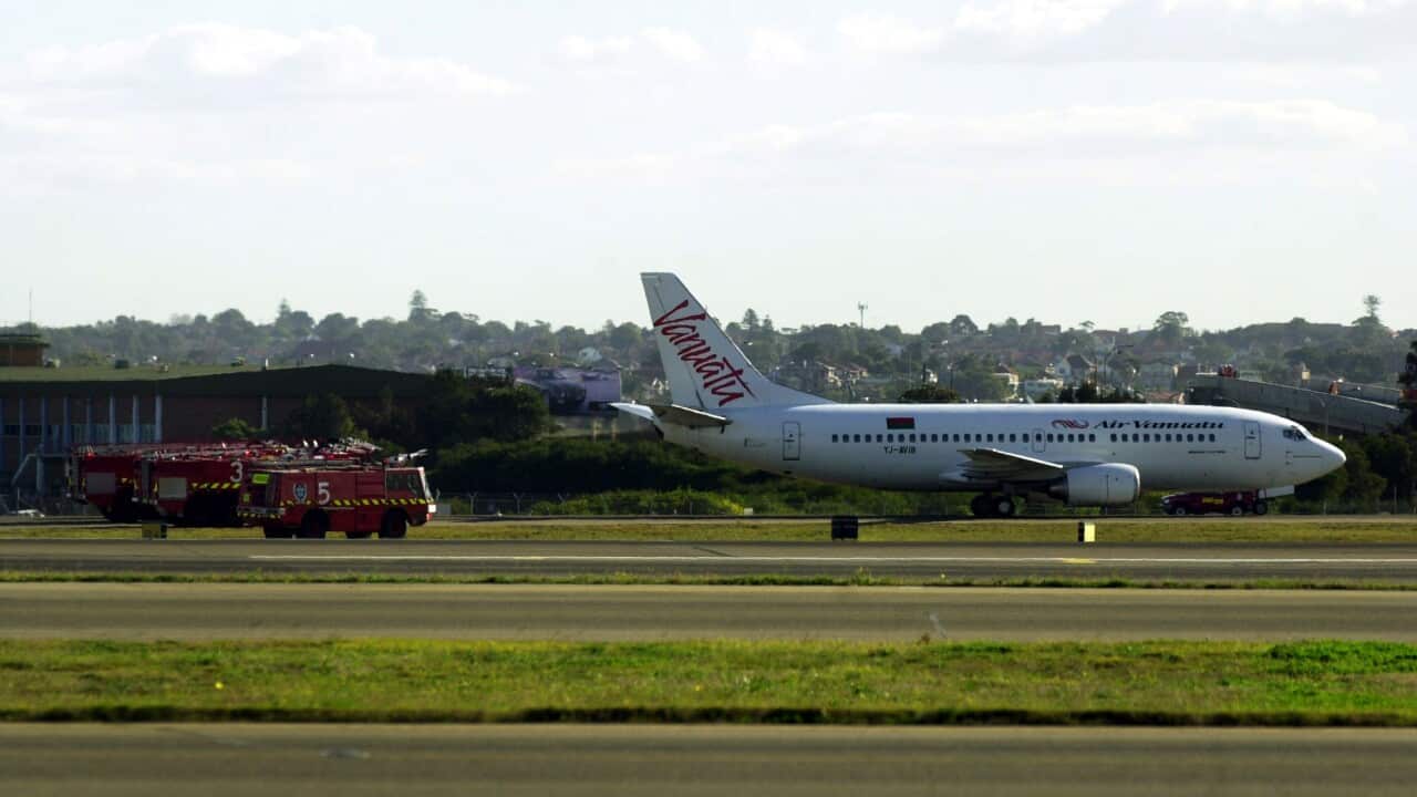 A plane travels across a runway amid green grass.
