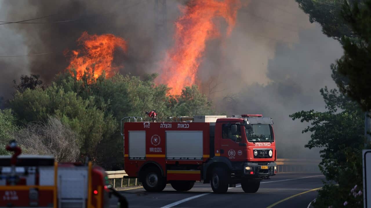 Firefighers douse flames caused by missiles fired from south Lebanon into northern Israel (AAP)