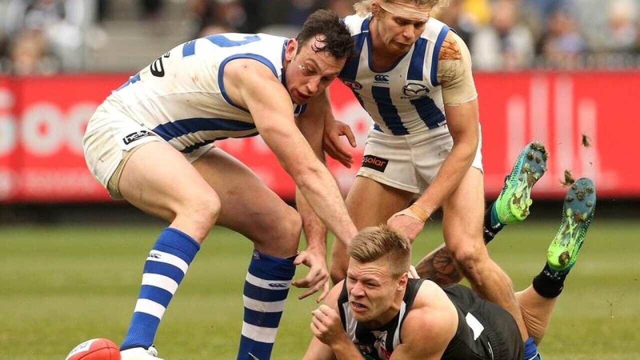 Jordan De Goey of the Magpies handpasses under pressure.