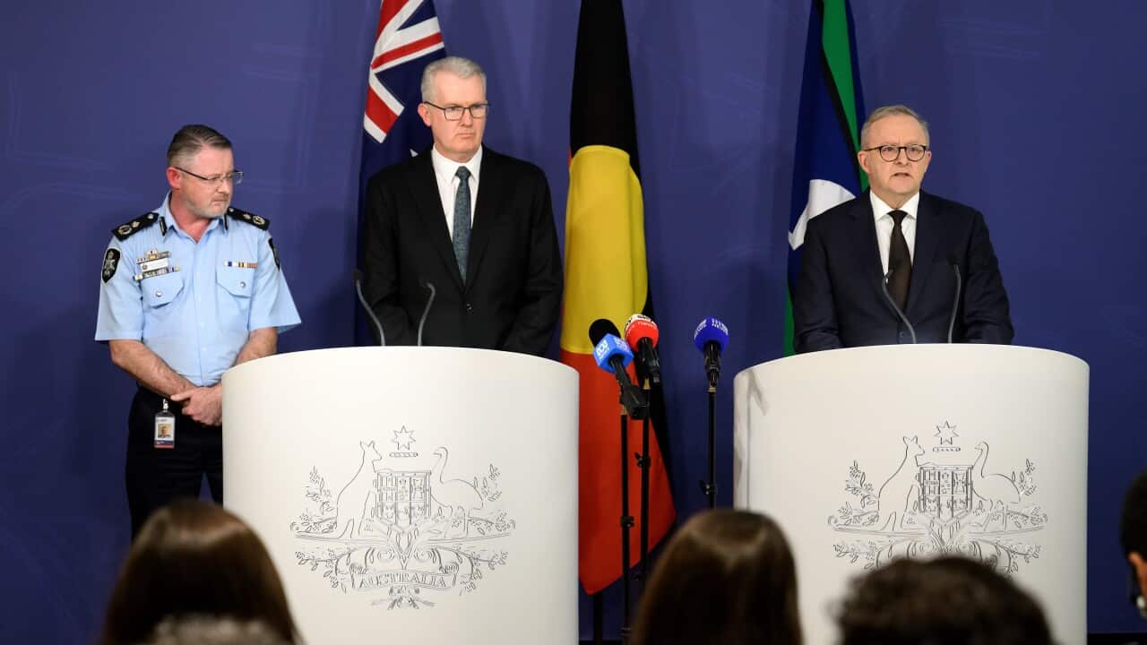 Three men standing in front of lecterns at a press conference.