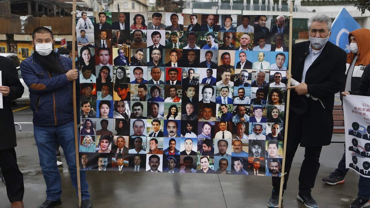 Members of the Uighur community living in Turkey hold a placard with photos of family members detained in Xinjiang. 