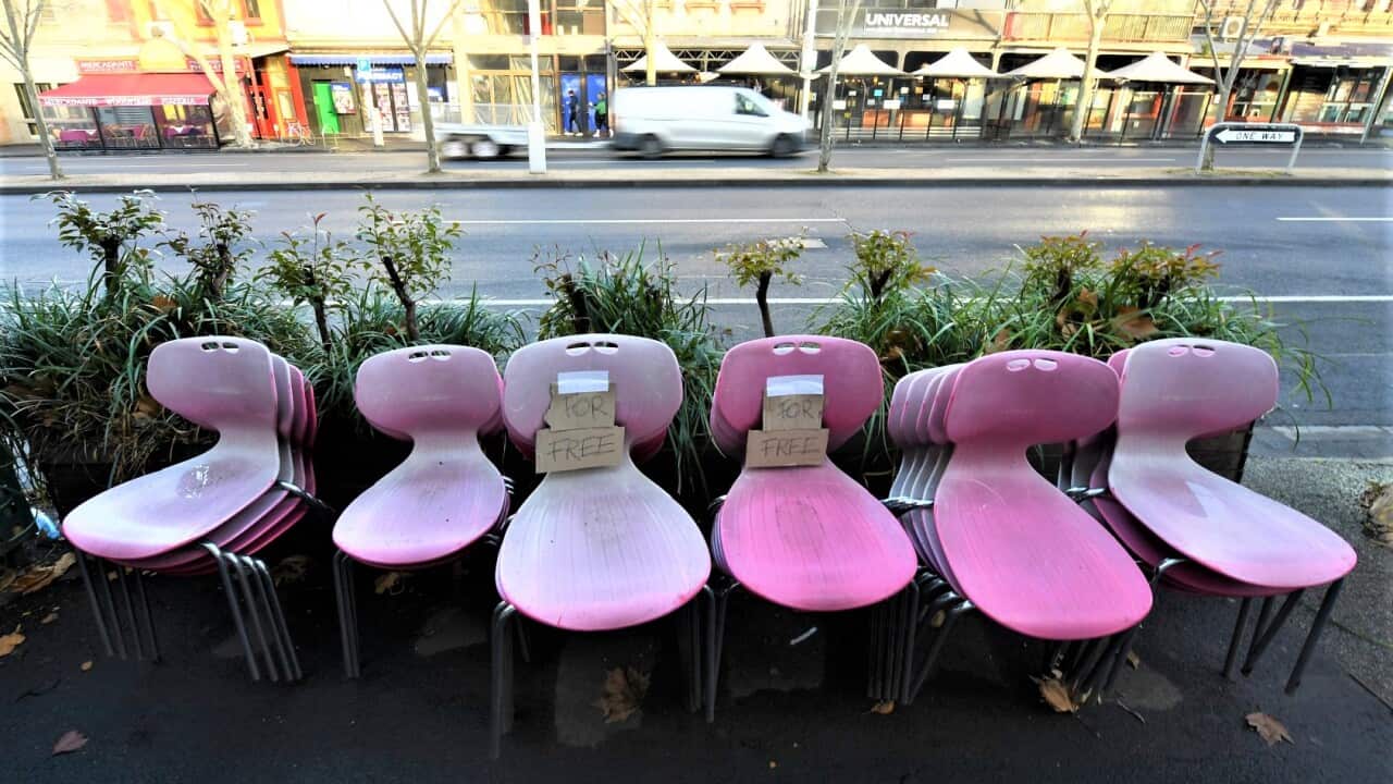 Free seats from a closed restaurant are seen along Lygon street in Melbourne.