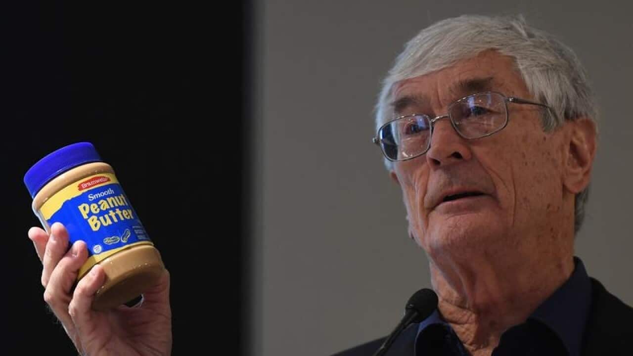 Dick Smith holds up a jar of peanut butter.