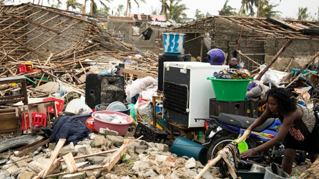 A woman hangs a cloth to dry in a sea of rubble after Tropical Cyclone Idai, in Beira, Mozambique