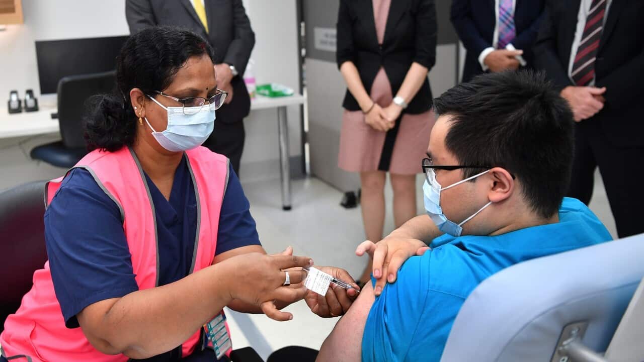 NSW Premier Gladys Berejiklian watches a radiographer get his first COVID vaccination