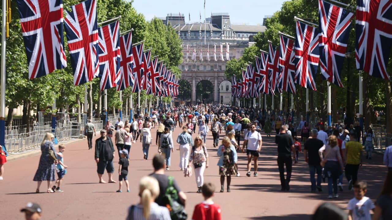 People walk along The Mall, decorated for the upcoming Platinum Jubilee of Britain's Queen Elizabeth II, in London, Sunday, May 22, 2022. (James Manning/PA via AP)