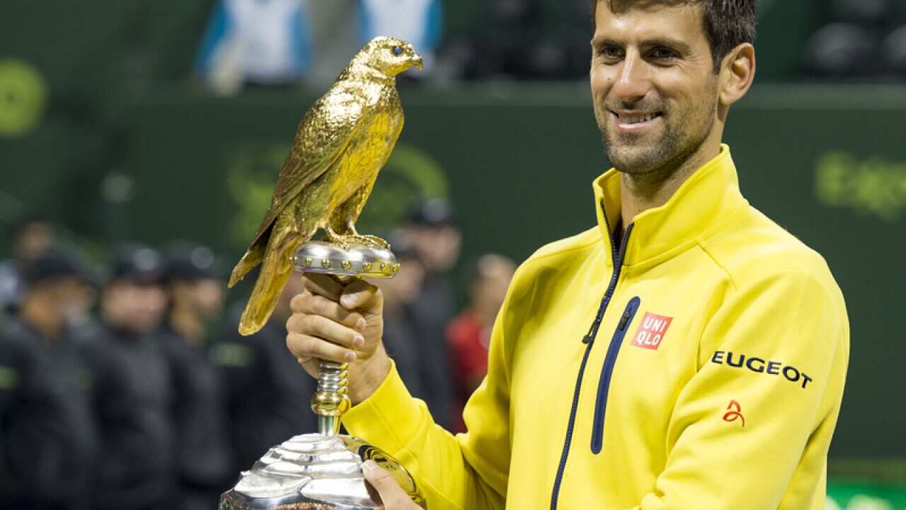 Novak Djokovic holds the trophy after he won the men's final match