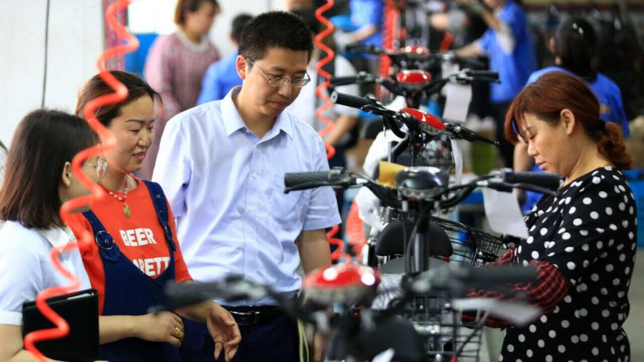 People work on the production line of electric bicycles in China
