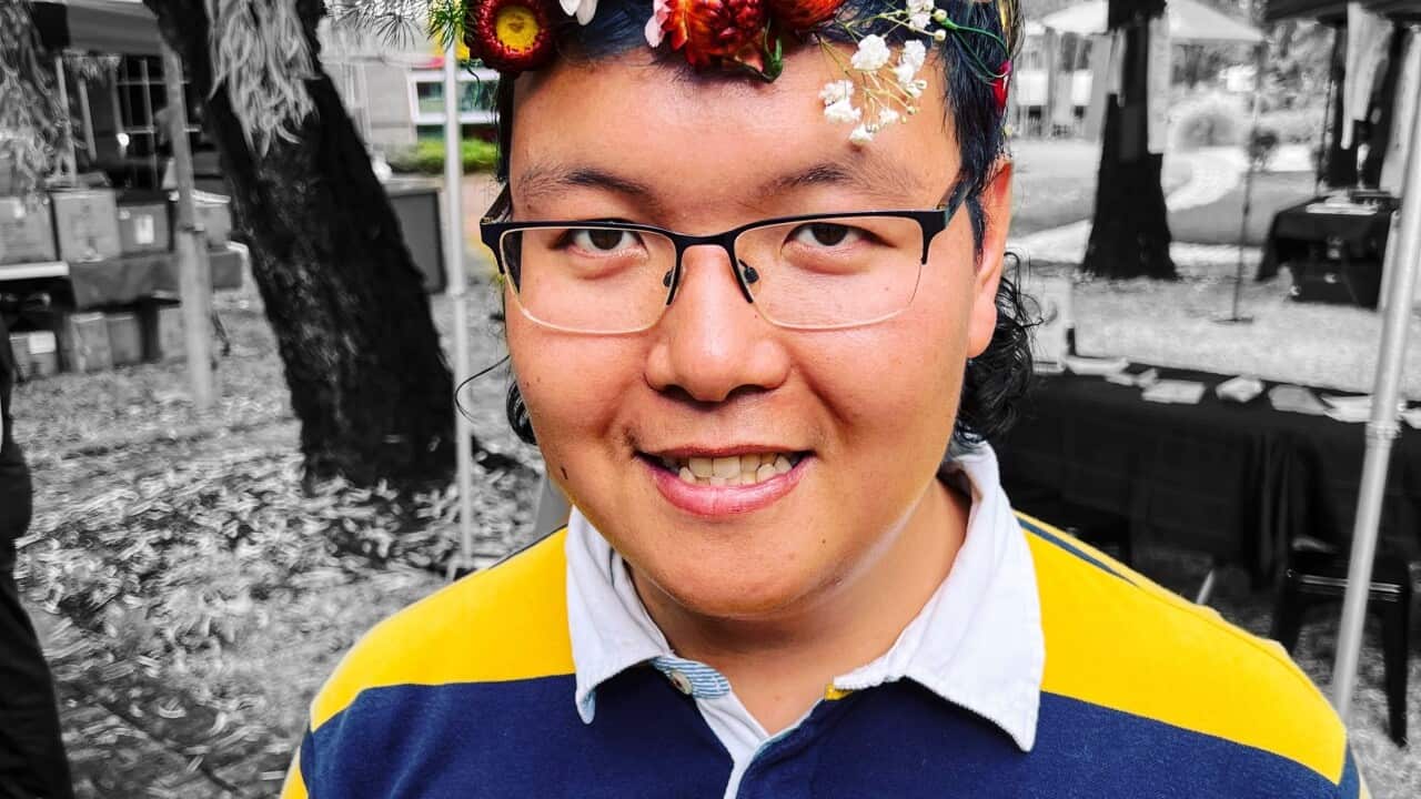 Reggie Chang is seen wearing a flower crown and smiling.