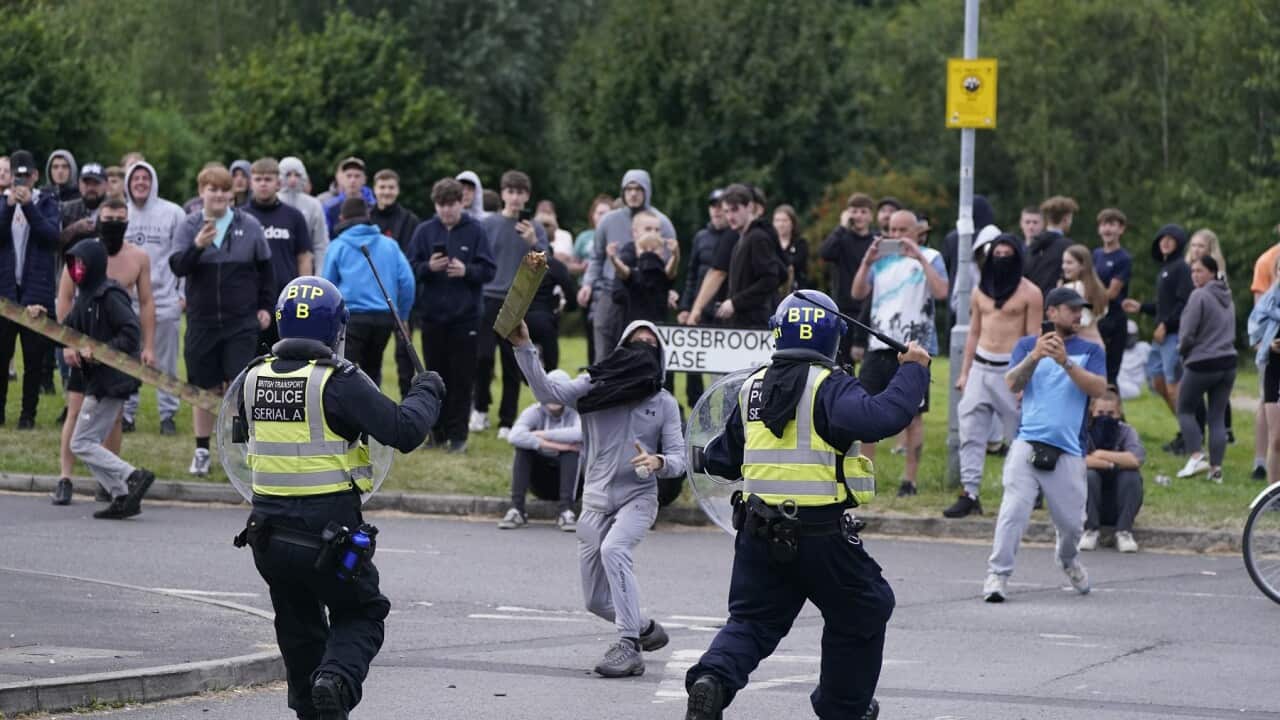 A youth aims a fence post at police during a demonstration near a hotel housing asylum seekers in Rotherham, South Yorkshire (AAP)