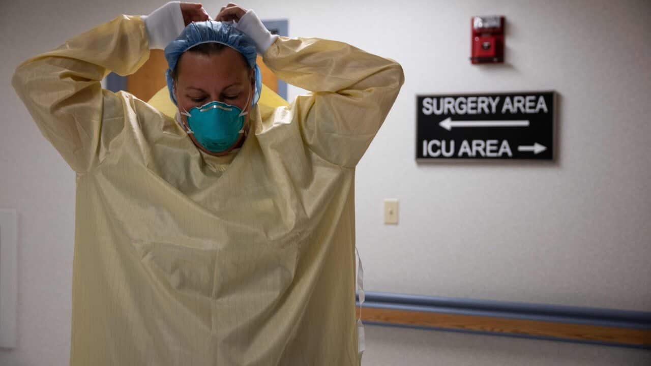 A healthcare professional suits up with PPE to enter a COVID-19 patient's room in the ICU at Van Wert County Hospital in Ohio on 20 November, 2020.