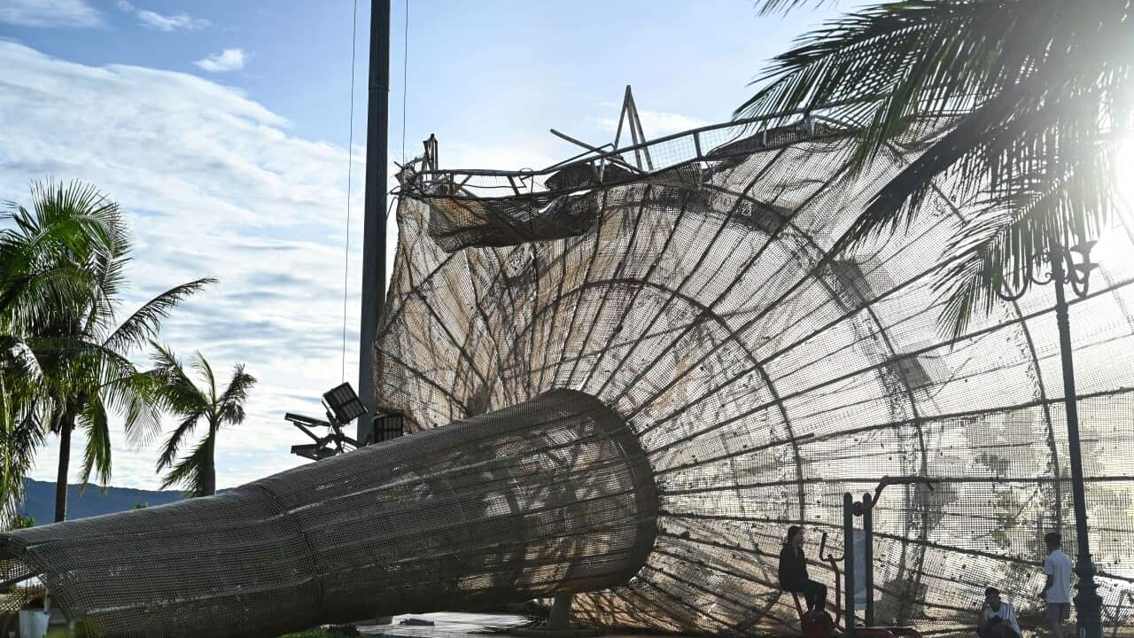 People rest near a structure, damaged by typhoon Kalmaegi