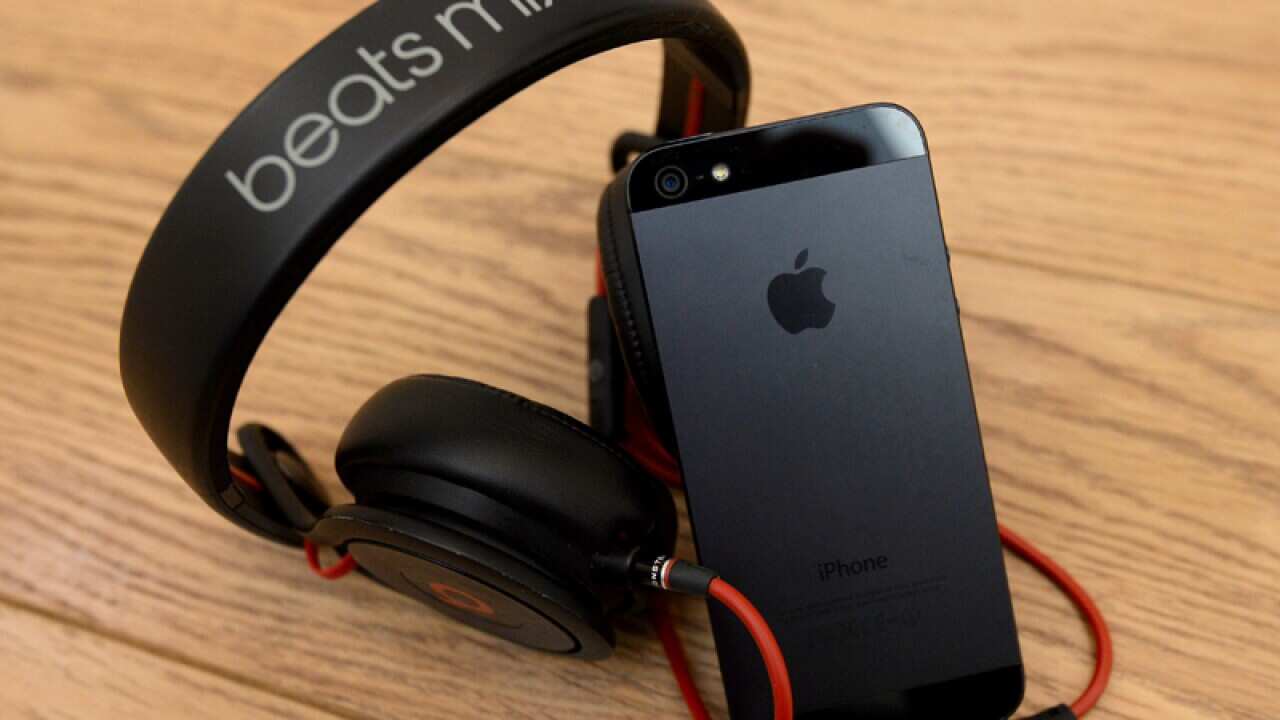 A pair of headphones alongside an iPhone