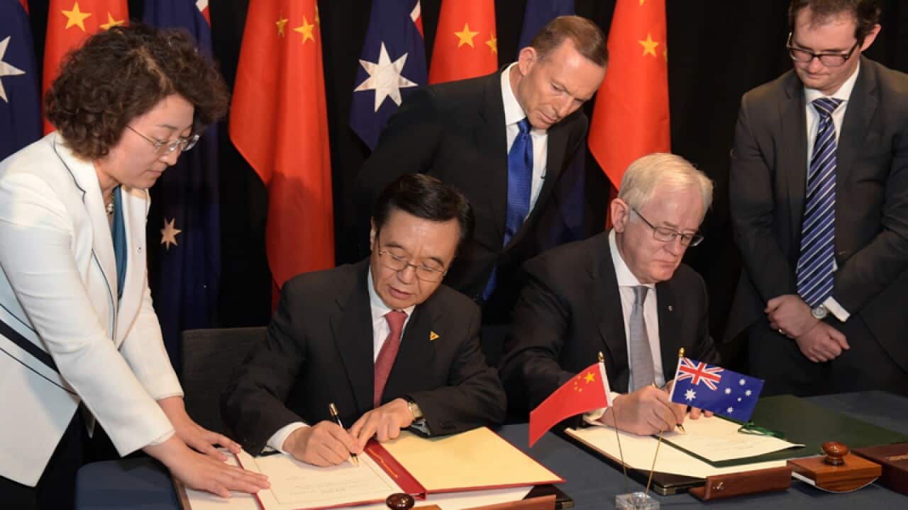 Chinese and Australian representatives sign a trade agreement