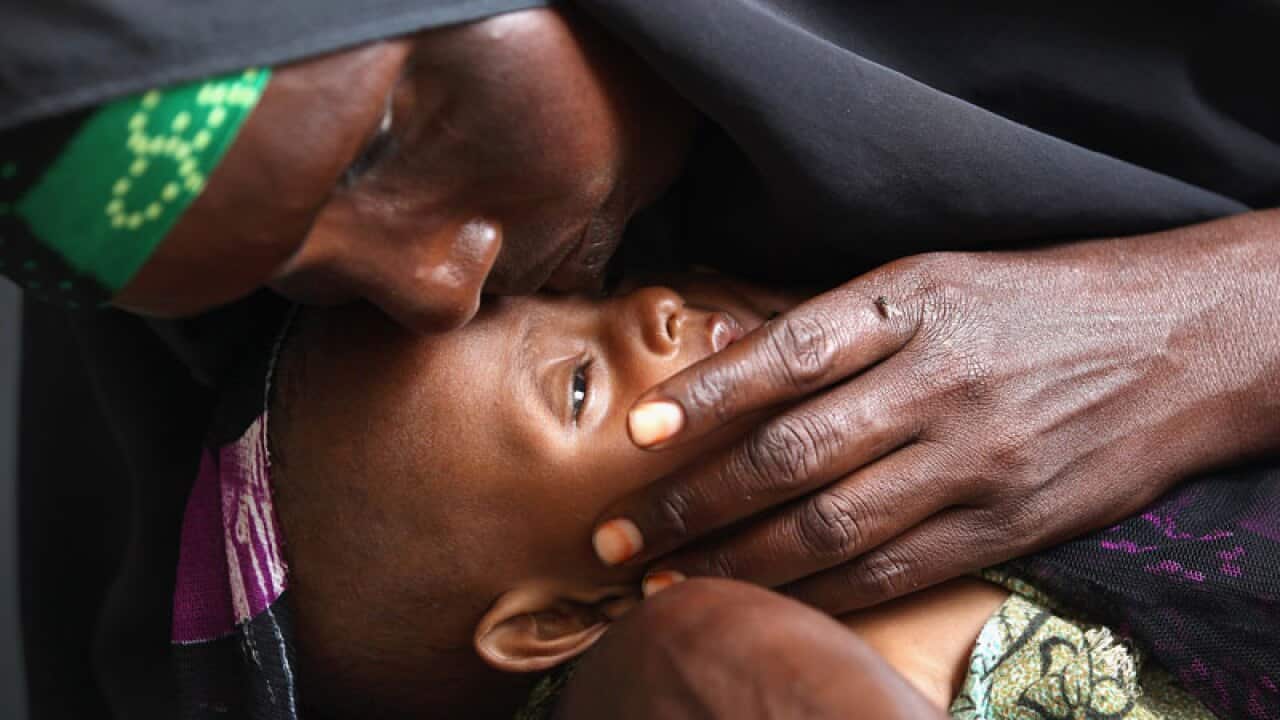 A Somali refugee waits to receive a food ration for her and her family at a food distribution point at the Dadaab refugee camp. (Getty)