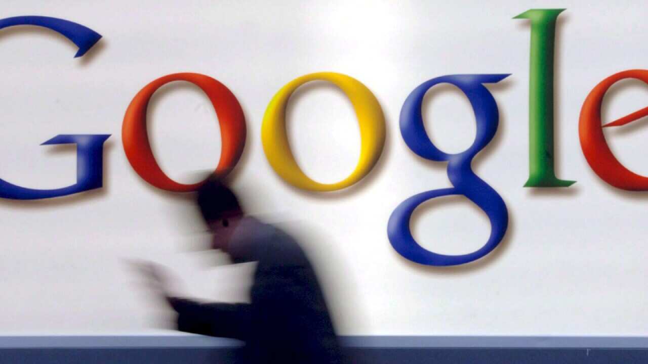 A man passes by a Google logo