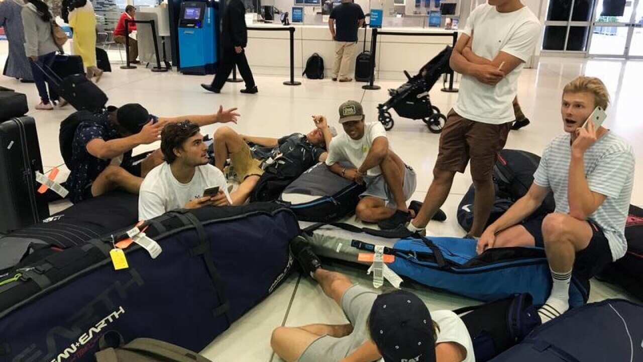 A group of surfers wait at Sydney Airport