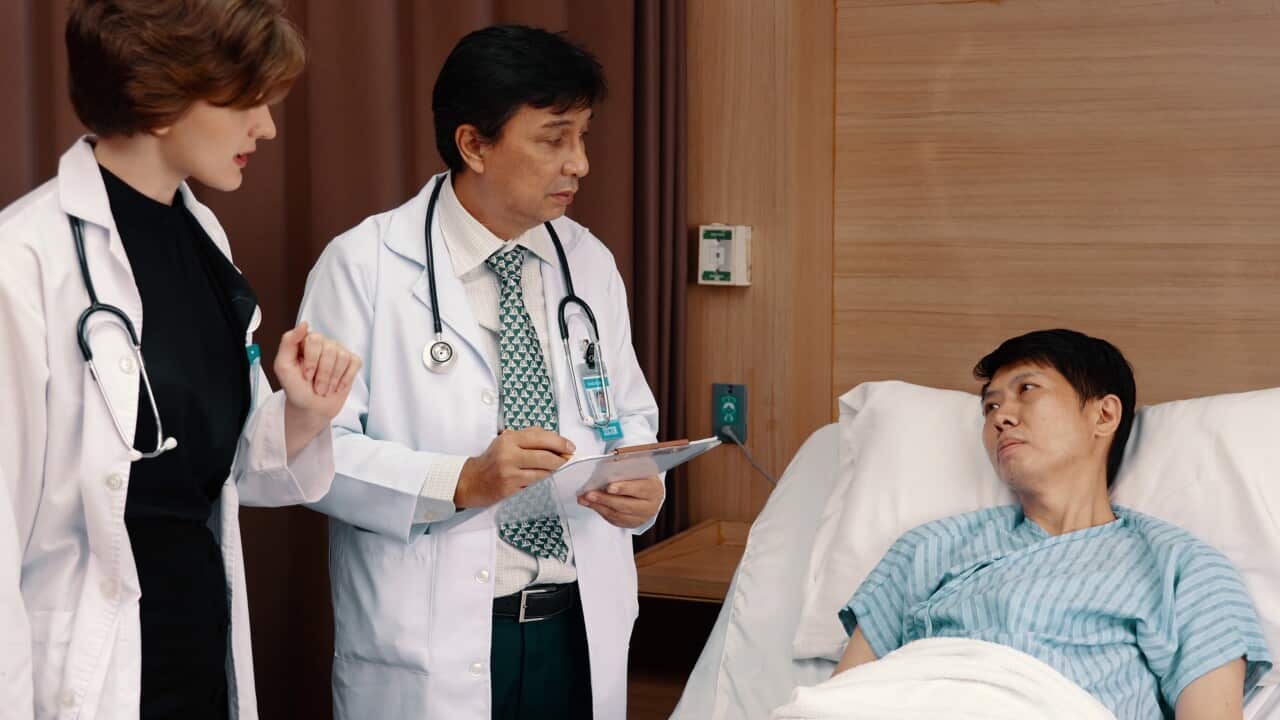 two-doctors-stand-and-talk-with-medical-reporttwo-doctor-talk-with-sick-man-in-hospita-SBI-351550597 (1).jpg