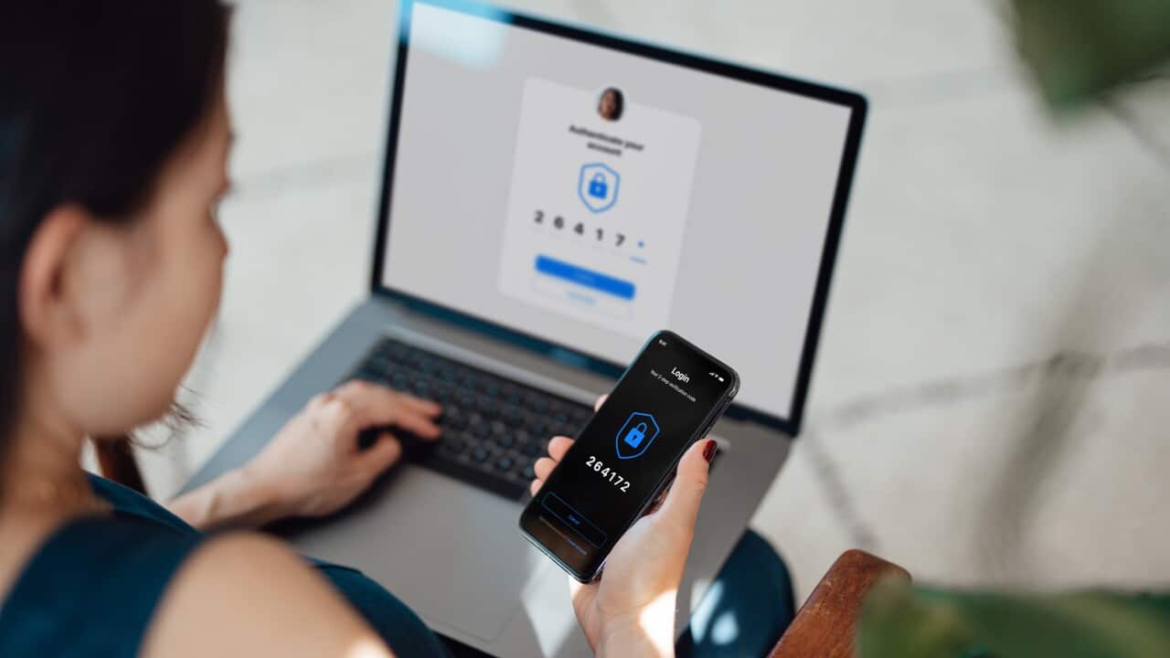 Businesswoman using laptop and mobile phone logging in online banking account