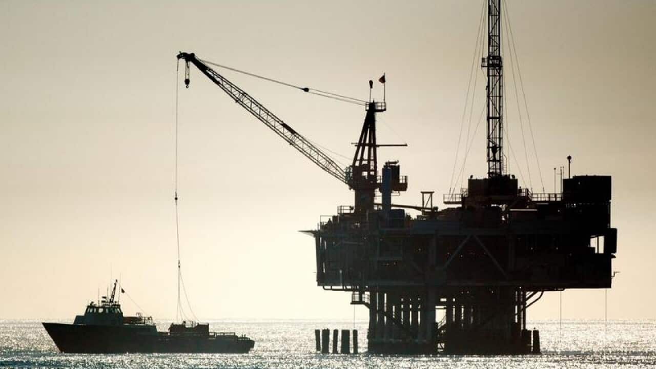 An oil drilling rig is seen off the Pacific Ocean coastline