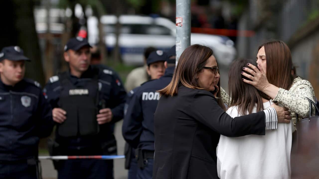 Teachers console students near the Vladislav Ribnikar elementary school in Belgrade