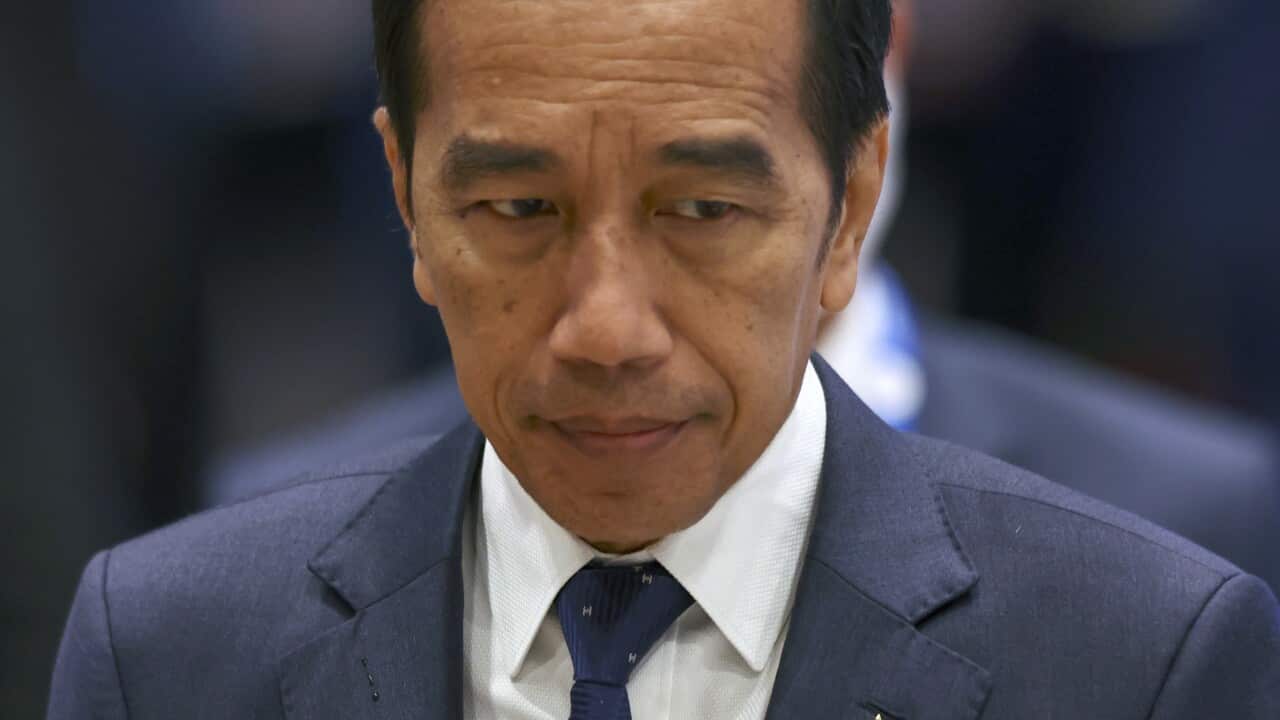 A man wearing a suit and tie walking.