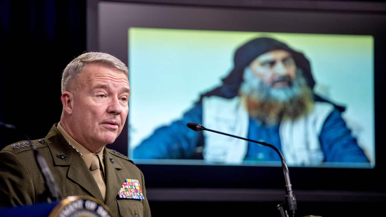 Abu Bakr al-Baghdadi is displayed on a monitor as General McKenzie speaks at a joint press briefing at the Pentagon.