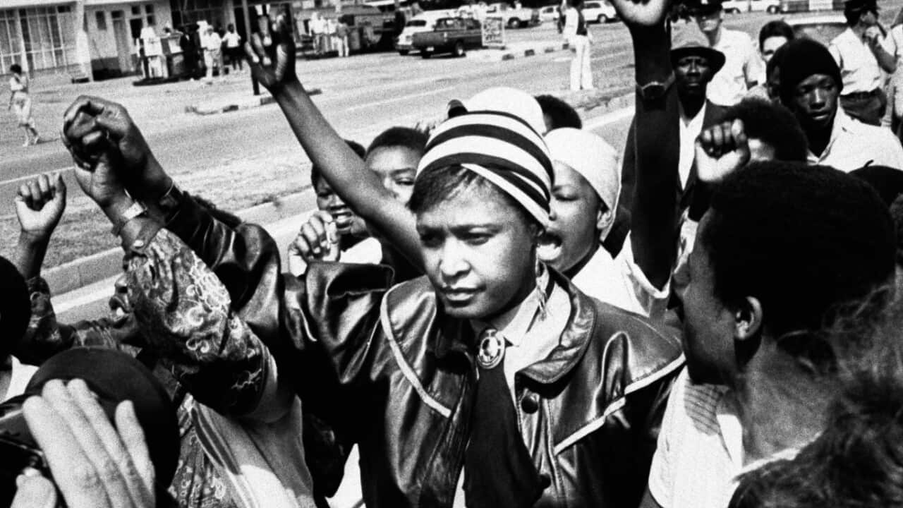 In this Jan. 22, 1986 file photo activist Winnie Mandela is cheered by supporters after appearing in the Krugersdorp Magistrate's court