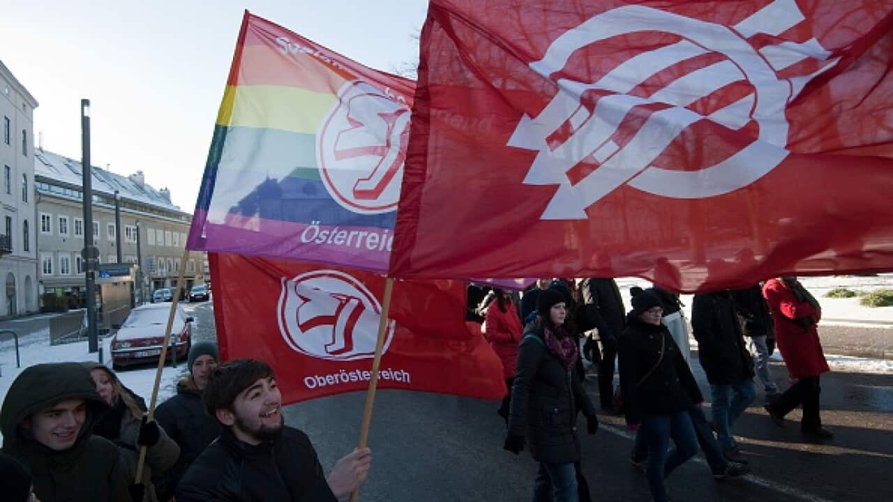 Countermarchers protesting against PEGIDA (Patriotic Europeans Against the Islamisation of the Occident) hold up flags as they demonstrate against a rally of the right-wing populist Pegida movement in Linz, Austria (AFP PHOTO / SAMUEL KUBANI)     