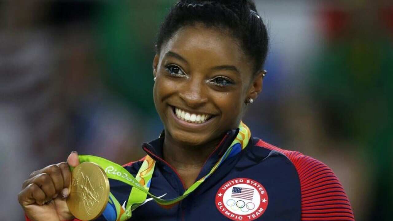 United States gymnast Simone Biles displays her gold medal