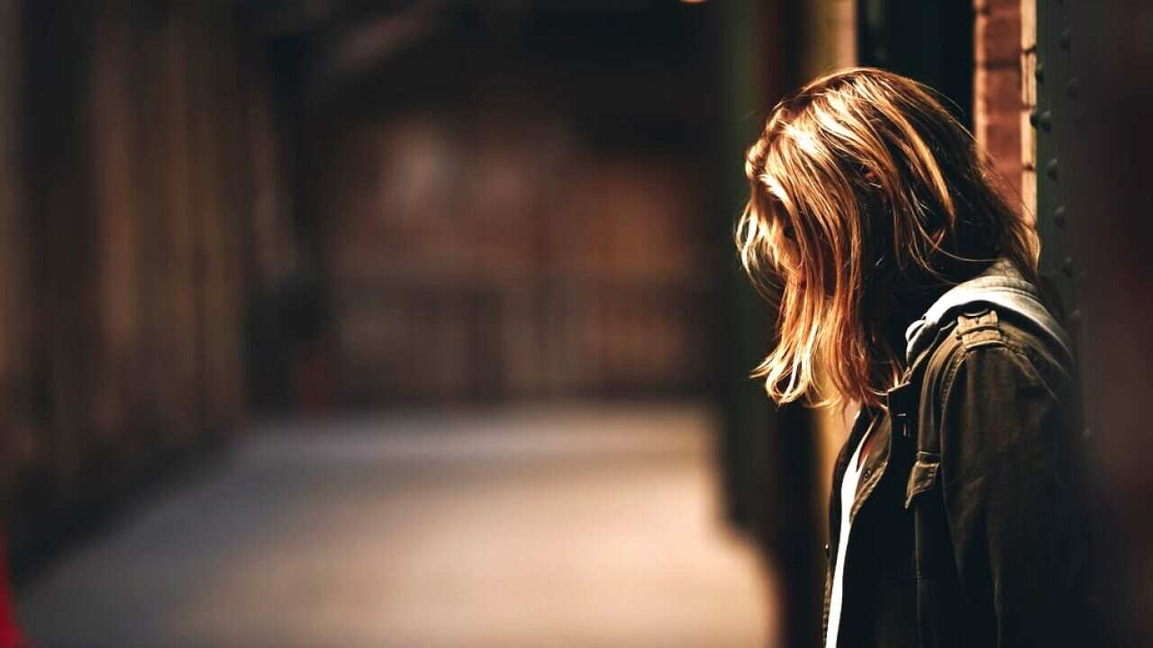 A girl stands in a hallway