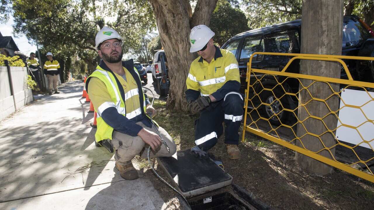 Contractors working with the rollout of the NBN network are seen in Sydney on July 10.