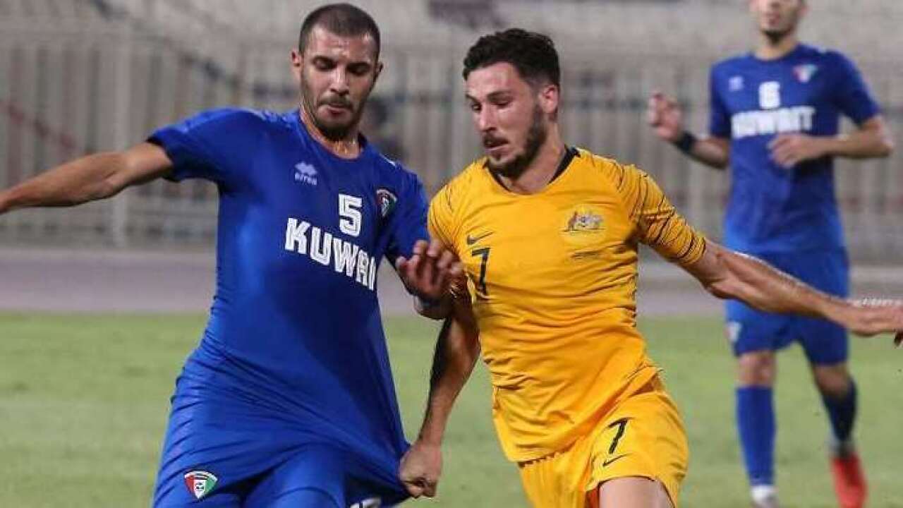 Mathew Leckie vies for the ball with Kuwait's Fahad al-Hajri - AFP