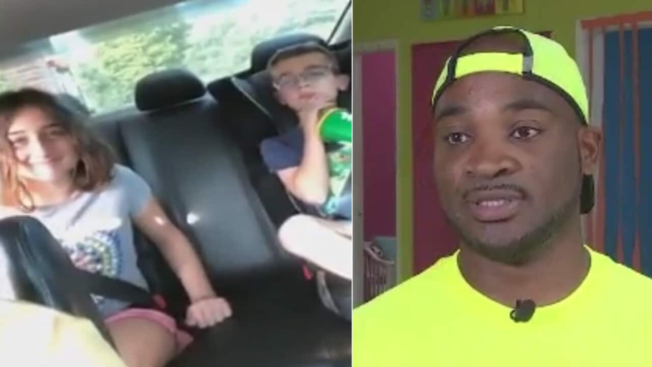 Corey Lewis (R) and the two children sitting in the back seat of his car 