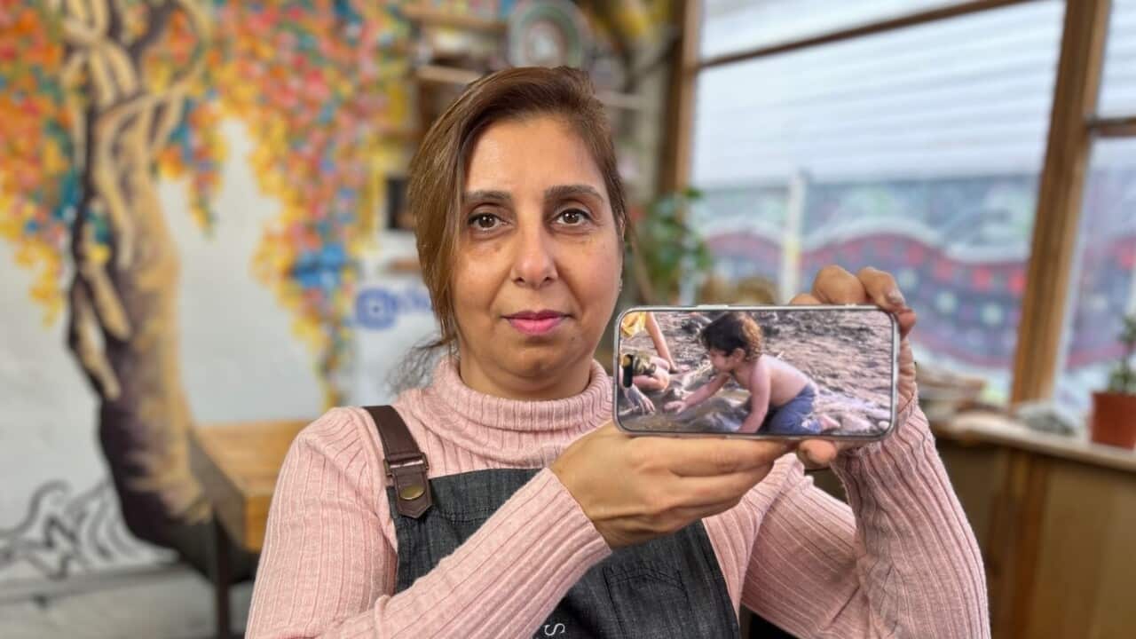 Nayran Tabiei with a photo of her young son, who has fled Tehran with his brothers (SBS Scott Cardwell).jpg
