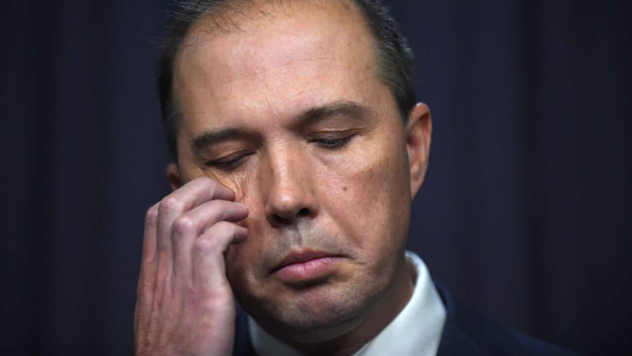 Peter Dutton scratches his face with his eyes closed.