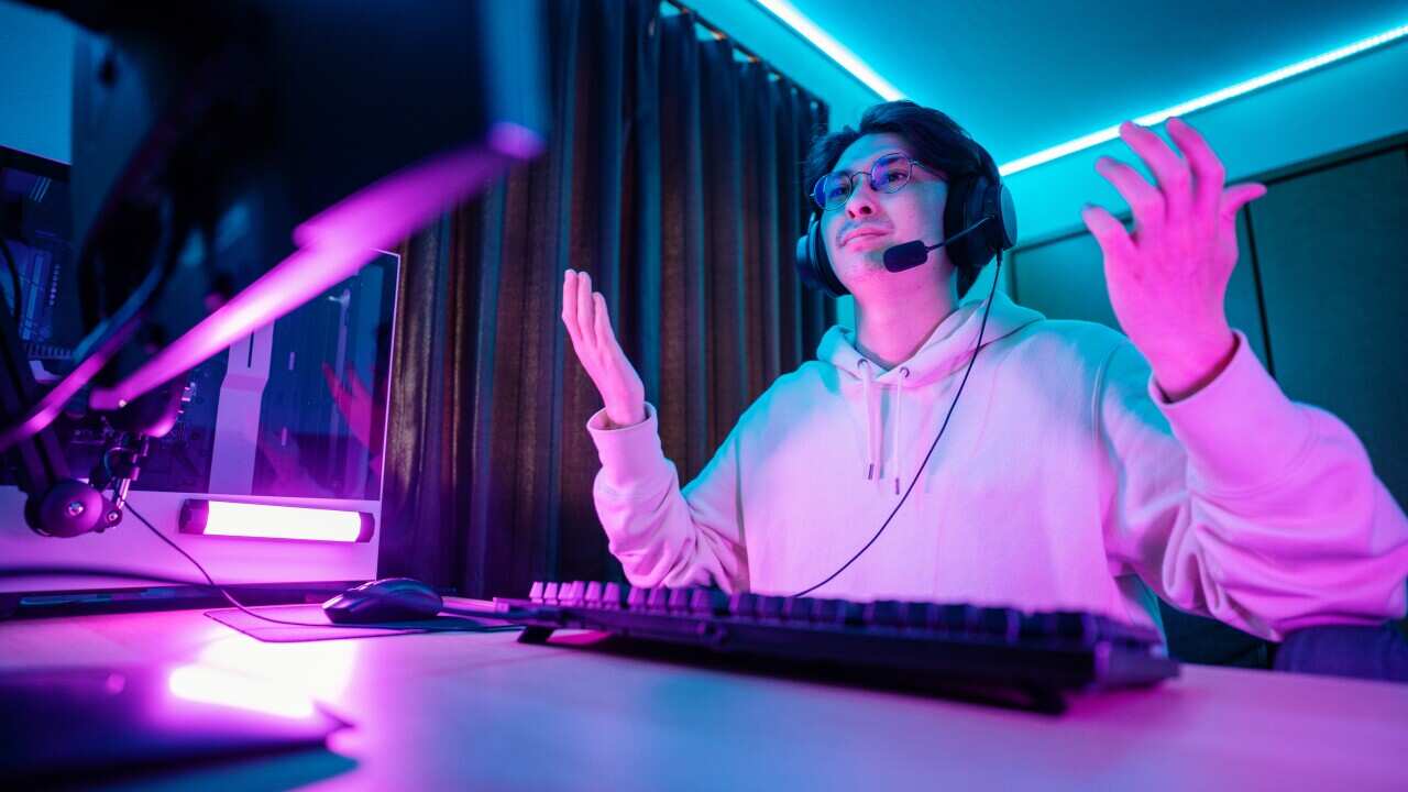 Millennial-aged man looking frustrated while playing E-sports on his computer