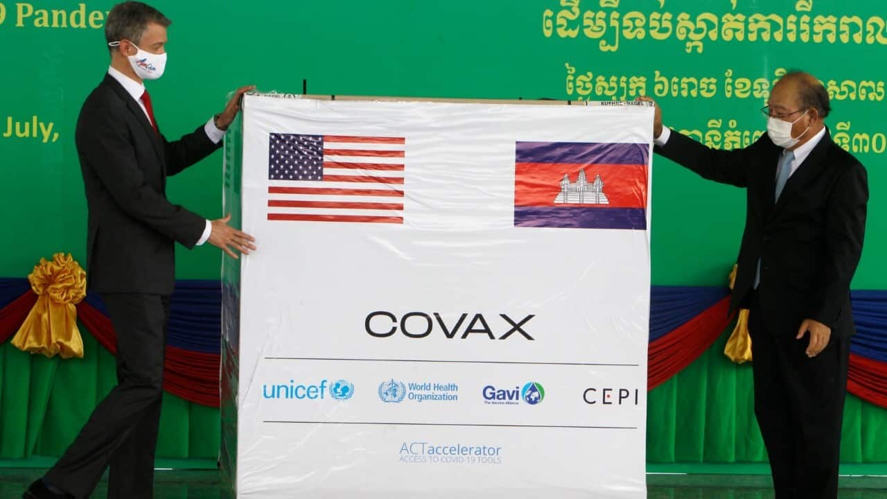 U.S. Embassy Deputy Chief of Mission Ben Wohlauer, left, presents a box of donated Johnson & Johnson COVID-19 Vaccines to Cambodian Health Minister Mam, July 30, 2021 (AP Image-AP Photo-Heng Sinith)
