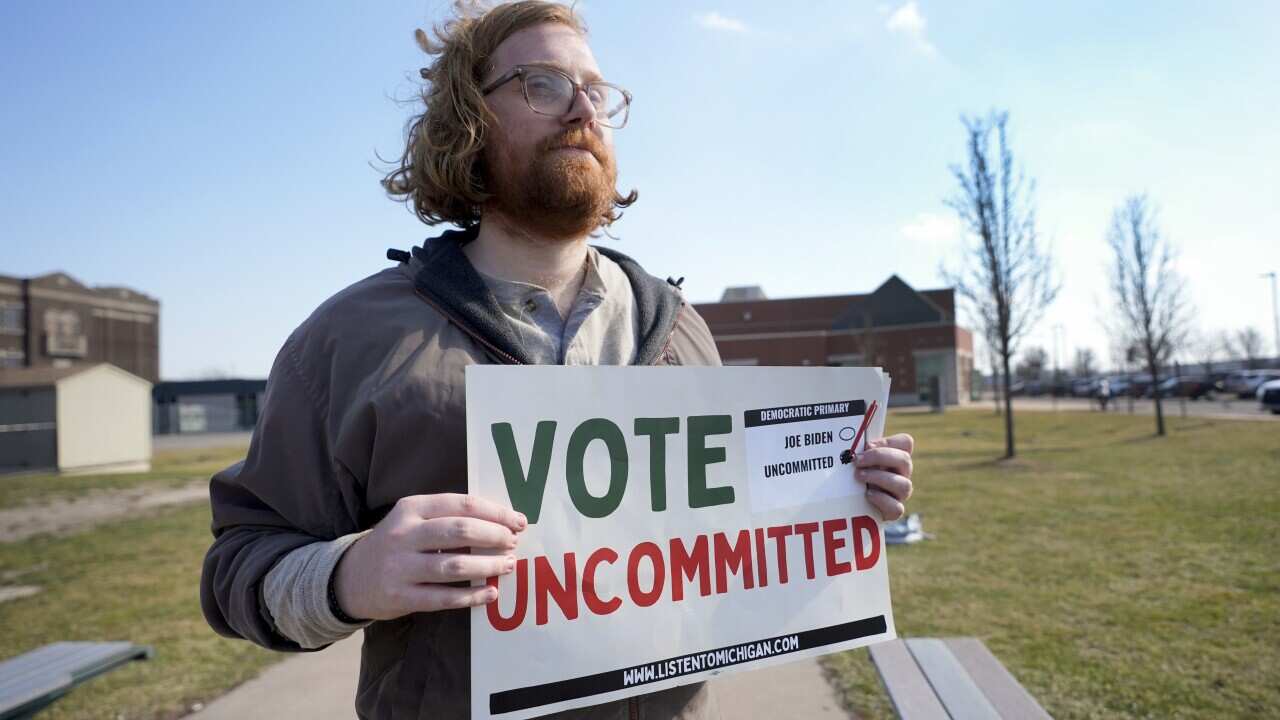 Eric Suter-Bull holds a Vote Uncommitted sign outside a voting location in Dearborn, Mich., Tuesday, Feb. 27, 2024.